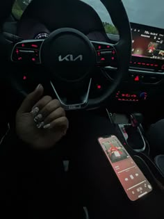 the interior of a car with an electronic device and steering wheel controls in front of it