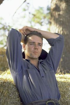 a man laying on the ground with his hands behind his head and looking at the camera