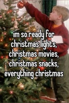 a young boy decorating a christmas tree with the words i'm so ready for christmas lights, christmas movies, christmas snacks, everything