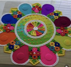 this is a colorful rug with flowers and circles in the center on a wooden table