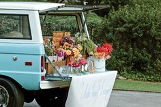 a blue truck with flowers and baskets on the back