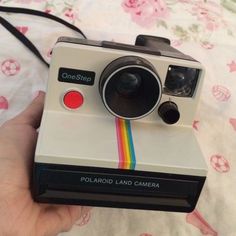 a person holding a polaroid camera in their hand