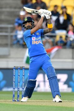 a man in blue uniform playing a game of cricket