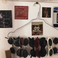 several pairs of sunglasses hanging on a wall with pictures and magnets attached to it