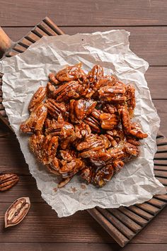 a pile of pecans sitting on top of a piece of paper next to some nuts