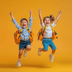 two children jumping in the air with backpacks on