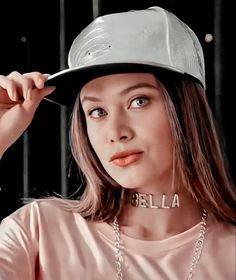 a woman wearing a hat and necklace with the word ella on it's collar