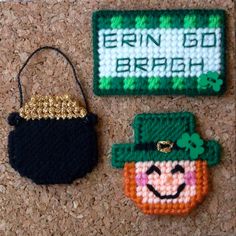 two small purses are sitting on the floor next to each other, one with a shamrock hat and another with a smiling face