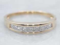 a yellow gold wedding band with princess cut diamonds