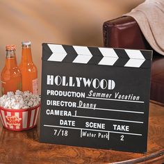 a wooden table topped with two bottles of soda and a clapper board on top of it