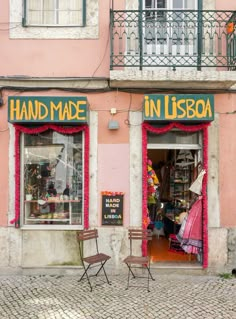 a store front with chairs and tables in front of it on a cobblestone street