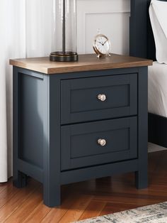 a night stand with two drawers and a clock on top