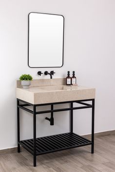 a bathroom sink sitting under a mirror next to a wall mounted faucet with a plant on it