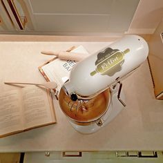 a kitchen counter with a mixer, book and utensils on top of it