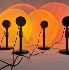 three black lamps sitting next to each other on top of a white cloth covered floor