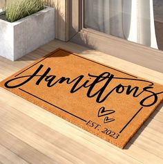 a welcome mat with the name harry on it in front of a door and potted plant