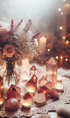 a table topped with lots of candles and vases filled with different types of flowers