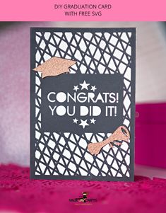 congratulations card with pink and black background on top of a purple tablecloth, featuring the words congrats you did it