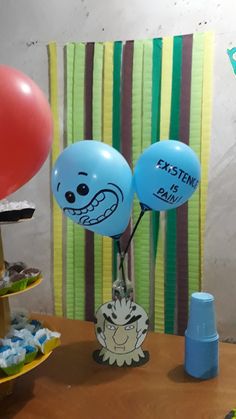 two balloons with faces on them sitting on a table