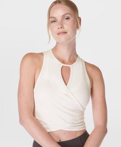 Our new wrap tank top, perfect for yoga, barre or pilates workouts. Soft touch fabric made from  modal Lenzing™ yarn. Slim cropped fit with a crew neck and wrap cut-out at front. Flattering seamless construction. Logo detailing at the front hem. Front length: 42cm / 16.5”. Model wears size S and is 178cm/5'10" tall. Style Code: SB9788Colour: Cloud White Wrap Vest, Wrap Tank Top, Pilates Workouts, Women's Vests, Yoga Barre, Construction Logo, Maternity Swimwear, Cloud White, Pilates Workout