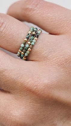 a woman's hand with a beaded ring on it