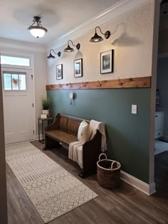 a living room with a wooden bench and pictures on the wall above it's door