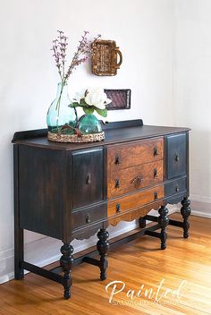 an old dresser with flowers on top and a vase sitting on it's side