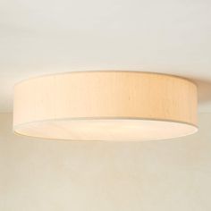 a light that is on in a room with a white wall behind it and the ceiling