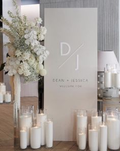 white flowers and candles are on display in front of a sign that says dj dean - jesica