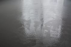 two people walking in the rain with umbrellas on an overcast day at night