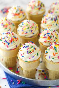 cupcakes with white frosting and colorful sprinkles on a plate