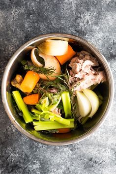 a metal bowl filled with different types of vegetables