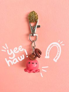 a keychain with a pink pig charm hanging from it's side on a pink background