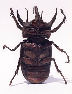 an insect sculpture sitting on top of a white surface