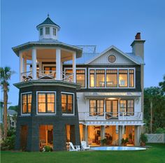 a large house sitting on top of a lush green field next to a swimming pool