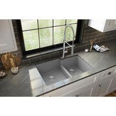 a kitchen sink with two faucets in the middle and a window behind it