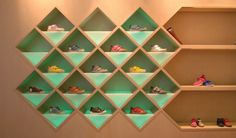 several shelves with various pairs of shoes on them in front of a wall mounted light