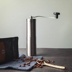 a coffee grinder sitting on top of a table next to a bag and beans