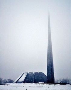 an obelisk in the middle of a snowy field