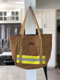 a brown bag hanging from the side of a white pole with a yellow and black stripe on it