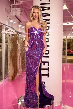 a woman in a purple dress standing next to a rack with dresses on display at a fashion store