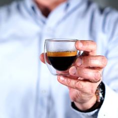 a man holding a glass filled with liquid