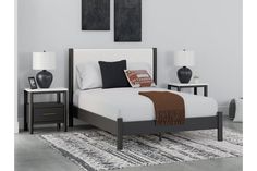 a bed sitting in a bedroom next to two nightstands on either side of the bed