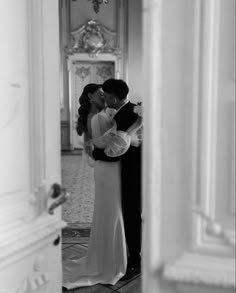 a bride and groom kissing in the hallway of their wedding reception at hotel du capucin