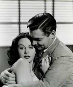 a man and woman embracing each other in black and white