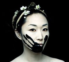 a woman with black and white face paint on her face