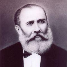 an old black and white photo of a man with a beard wearing a tuxedo