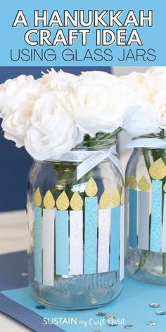 two mason jars with candles and flowers in them on a blue tablecloth that says, a hanukkah craft idea using glass jars