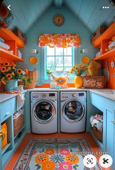 a washer and dryer in a small room with orange decor on the walls