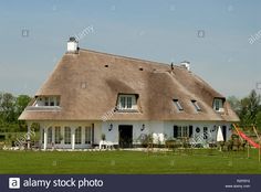 a large white house with a thatched roof